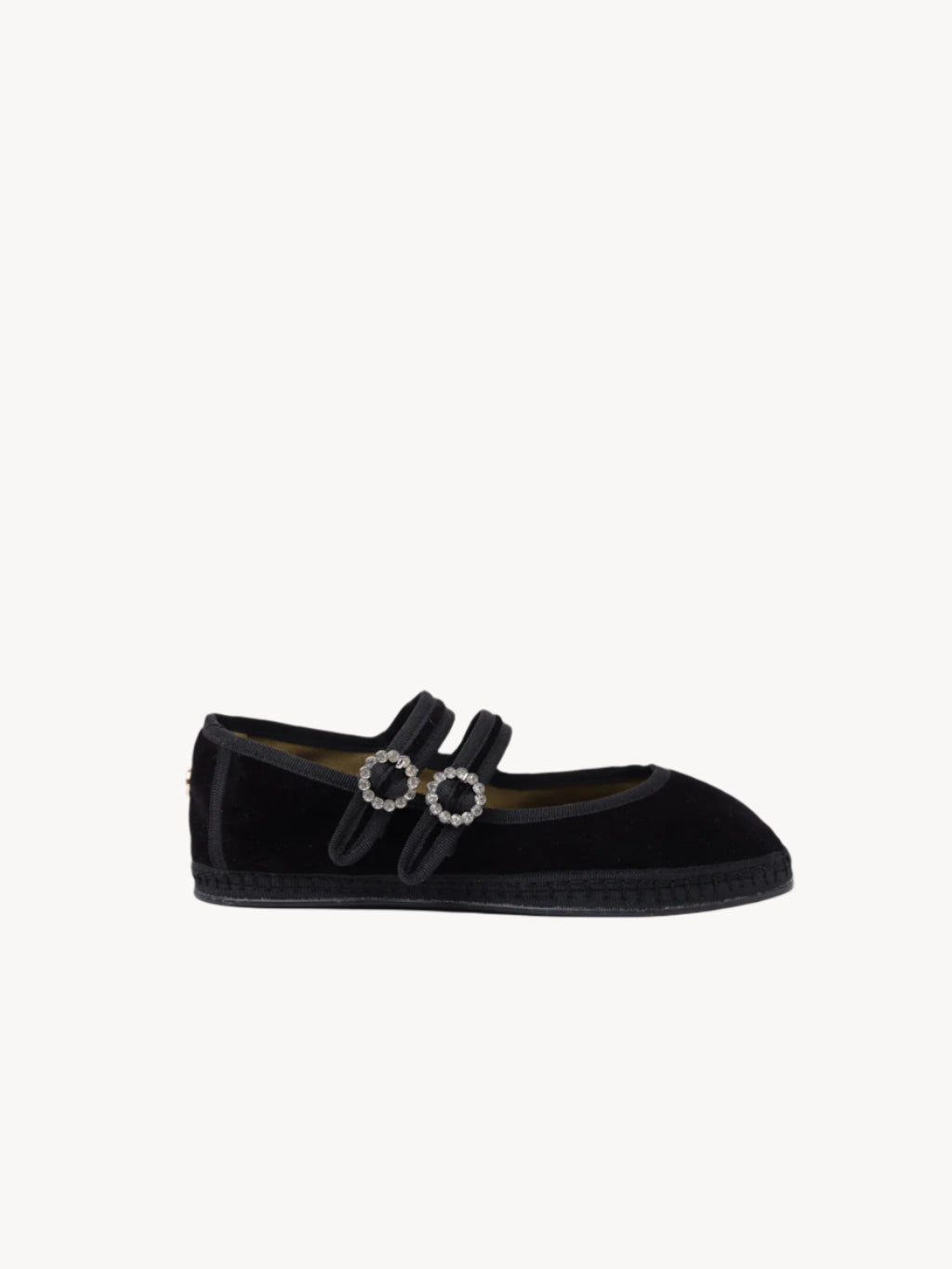Black velvet shoe with decorative elements on a light background