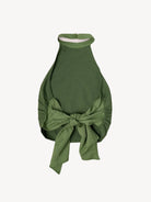 Green halter top with a bow on a light beige background