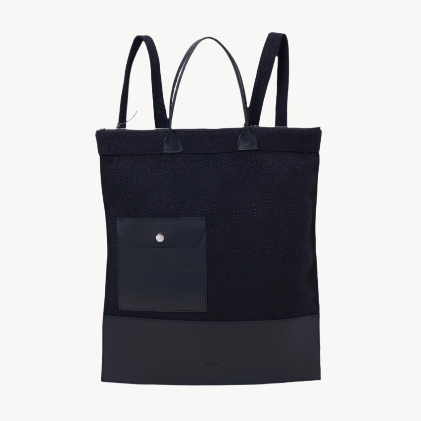 A black backpack with two handles, an interior pocket, and is made of a fabric that appears to be a blend of recycled plastic and vegetable tanning.